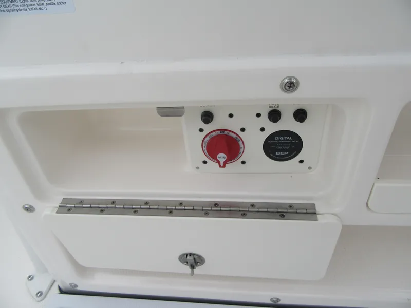 Slide: The Image of Control panel of 2025 Robalo R200 Center Console boat, featuring switches and a red dial. - 19