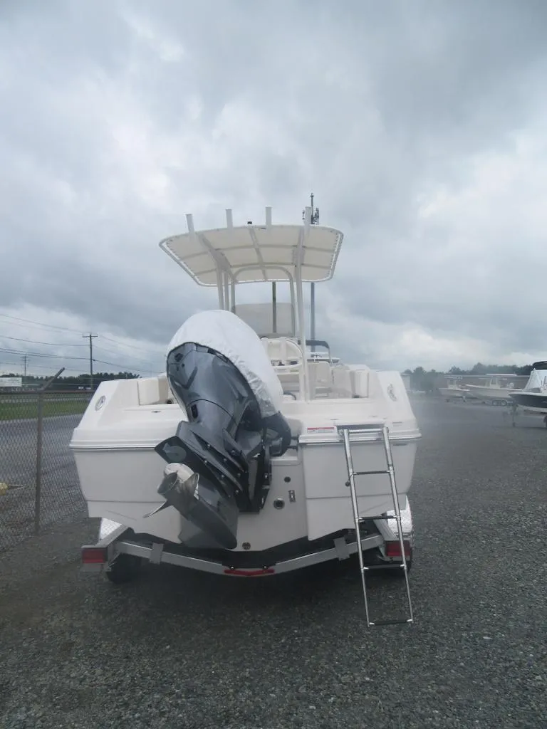 Slide: The Image of 2025 Robalo R200 Center Console boat with outboard motor, parked on gravel under cloudy skies. - 4