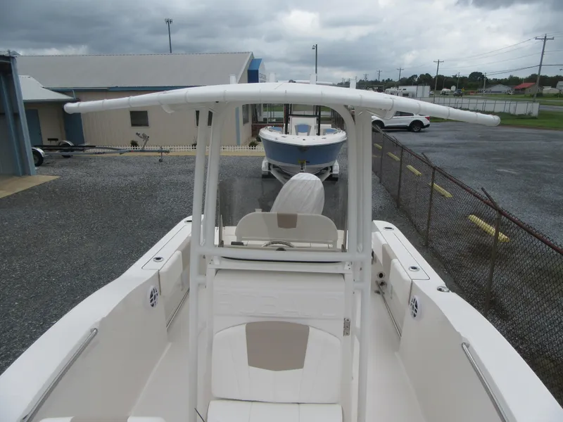 Slide: The Image of 2025 Robalo R200 Center Console boat, white exterior, parked outdoors on gravel. - 6