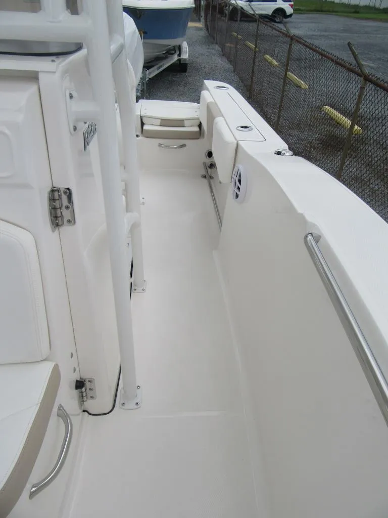 Slide: The Image of 2025 Robalo R200 Center Console boat deck, featuring sleek white design and sturdy railings. - 8