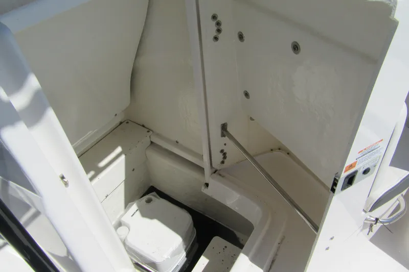 Slide: The Image of 2025 Robalo R200 Center Console boat interior storage compartment with portable toilet. - 15
