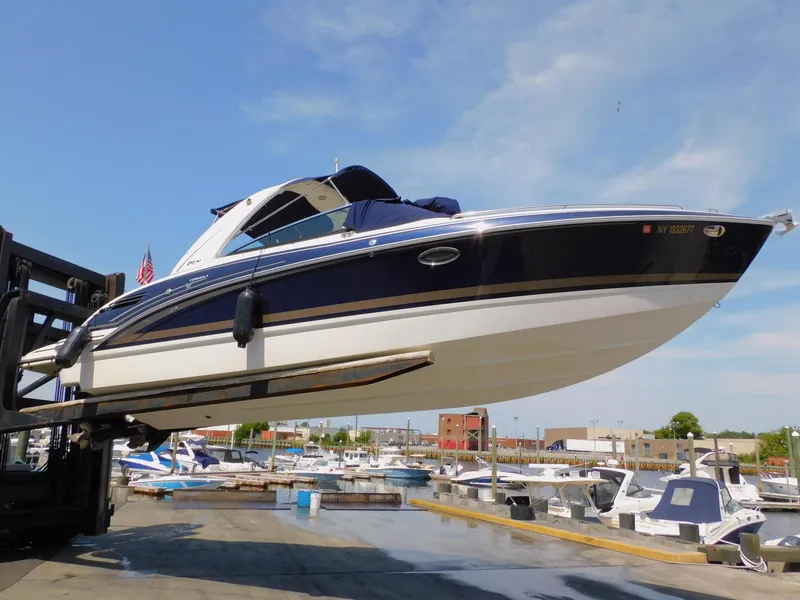 Slide: The Image of 2015 Formula Bowrider 290 boat lifted at marina, clear sky background. - 10