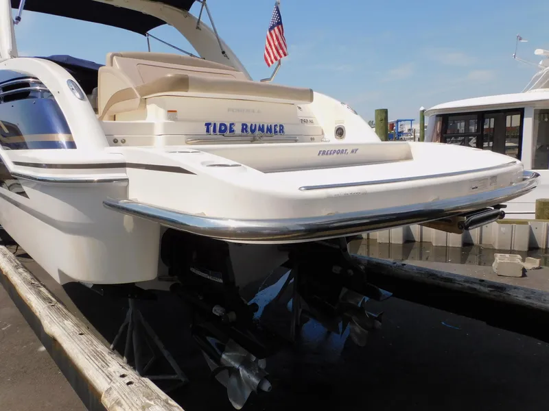 Slide: The Image of 2015 Formula Bowrider 290 boat docked, rear view with American flag. - 11