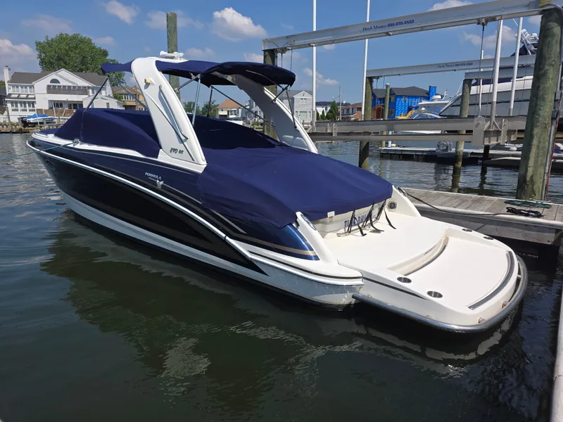 Slide: The Image of A 2015 Formula Bowrider 290 docked, featuring a blue cover. - 1