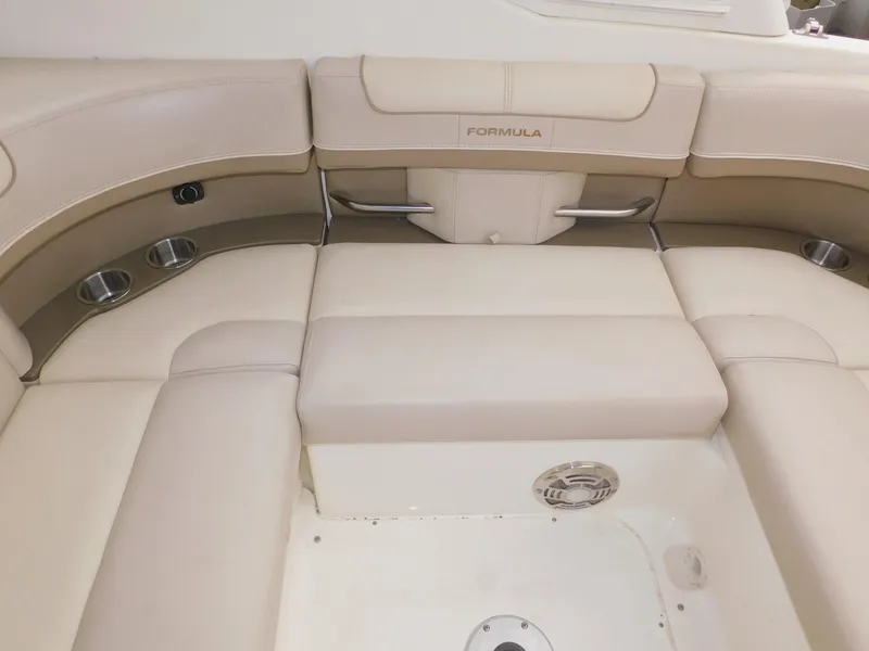 Slide: The Image of 2015 Formula Bowrider 290 interior seating with beige upholstery and cup holders. - 30