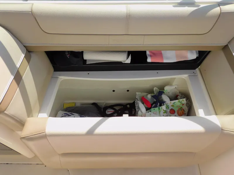 Slide: The Image of 2015 Formula Bowrider 290 storage compartment with beige seating and various items inside. - 43