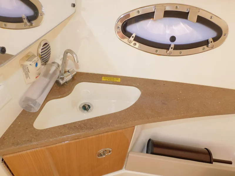 Slide: The Image of 2015 Formula Bowrider 290 bathroom sink with countertop and porthole window. - 47