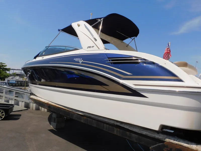Slide: The Image of 2015 Formula Bowrider 290 boat with sleek design, docked under clear blue sky. - 8