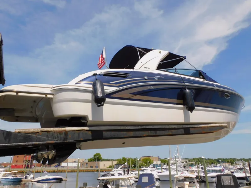 Slide: The Image of 2015 Formula Bowrider 290 boat lifted at marina, blue sky background. - 9