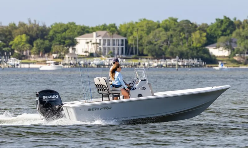 Slide: The Image of 2024 Sea Pro 210 Bay boat cruising on a lake with a Suzuki outboard motor. - 0