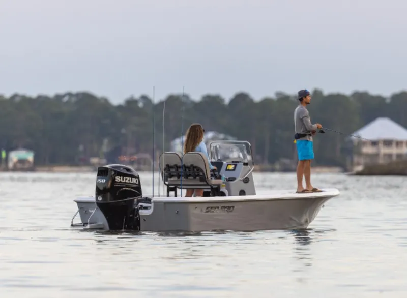 Slide: The Image of 2024 Sea Pro 210 Bay boat with Suzuki engine on calm water. - 2