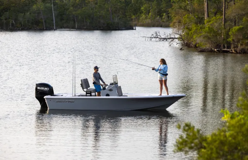 Slide: The Image of 2024 Sea Pro 210 Bay boat on a serene lake with two people fishing. - 3