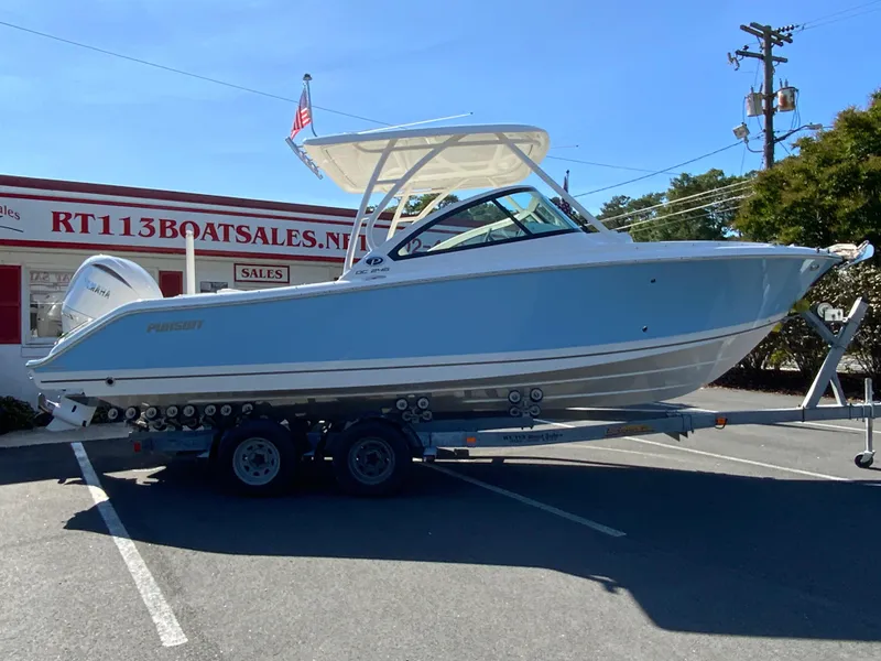 Slide: The Image of 2025 Pursuit DC 246 Dual Console boat on trailer at dealership. - 1