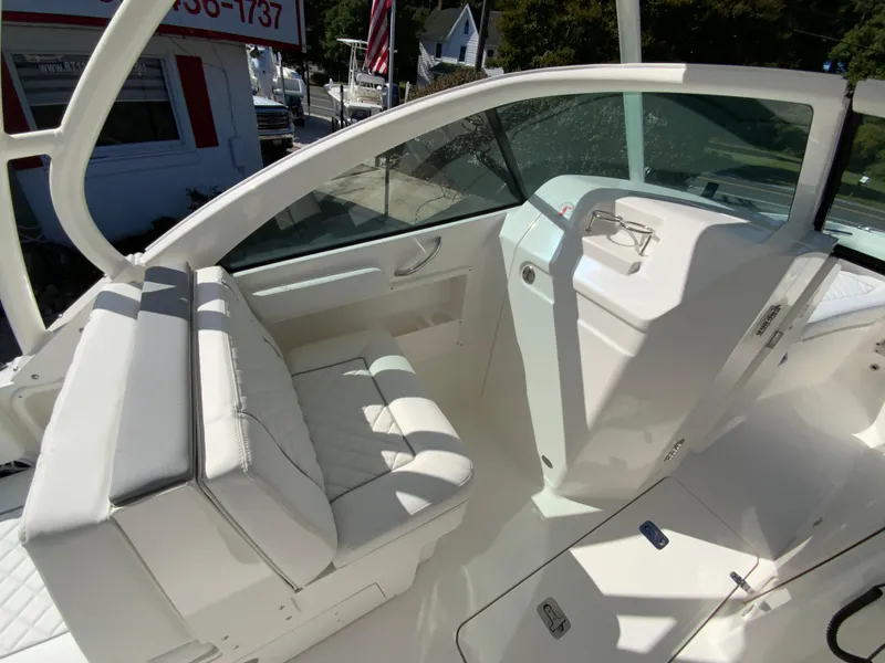 Slide: The Image of 2025 Pursuit DC 246 Dual Console boat interior with white seating and helm. - 13