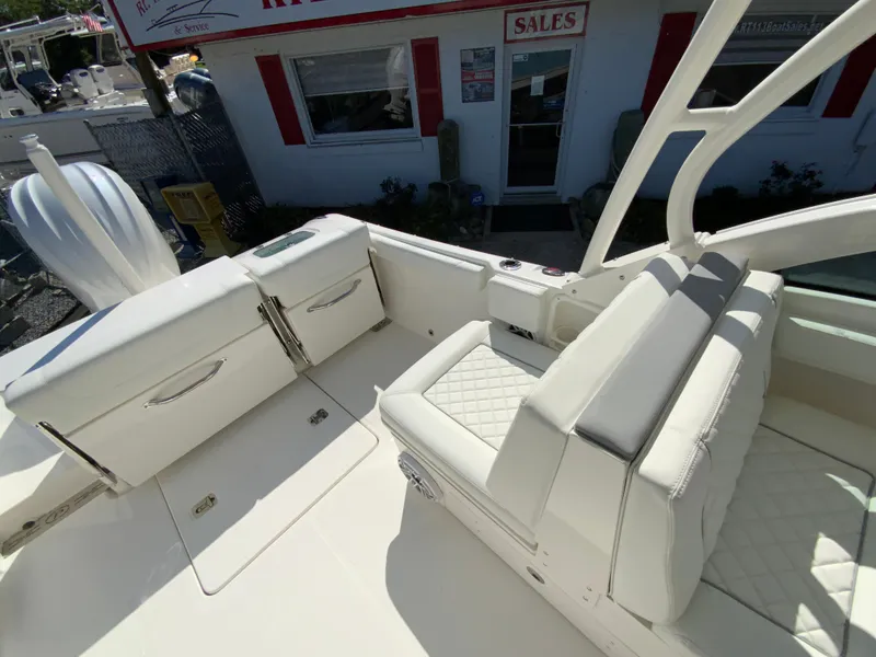 Slide: The Image of 2025 Pursuit DC 246 Dual Console boat interior with white seating and storage compartments. - 14