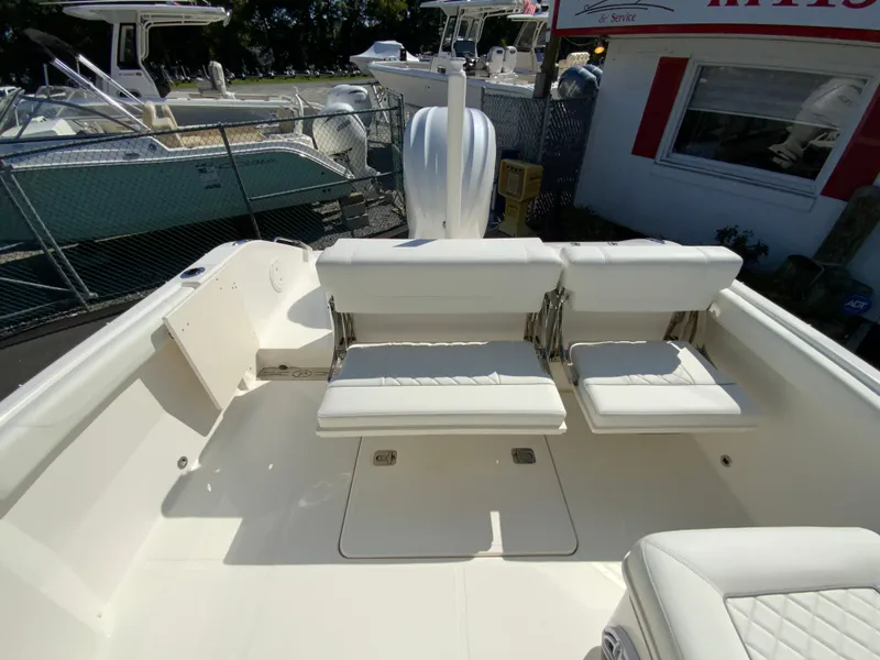 Slide: The Image of 2025 Pursuit DC 246 Dual Console boat interior with white seating and deck. - 18