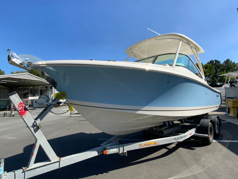 Slide: The Image of 2025 Pursuit DC 246 Dual Console boat on trailer, parked outdoors. - 4