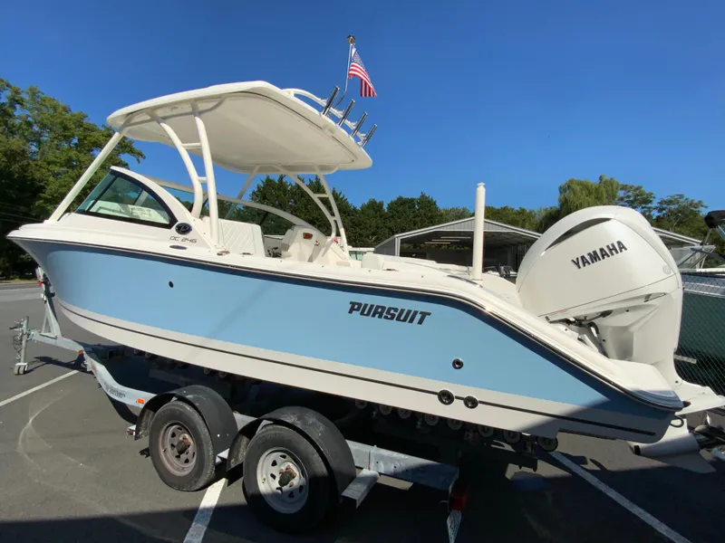 Slide: The Image of 2025 Pursuit DC 246 Dual Console boat on trailer, featuring Yamaha engine. - 6