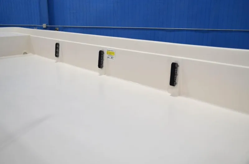 Slide: The Image of 2024 Carolina Skiff E24 DLX TH boat interior with white deck and blue background. - 2