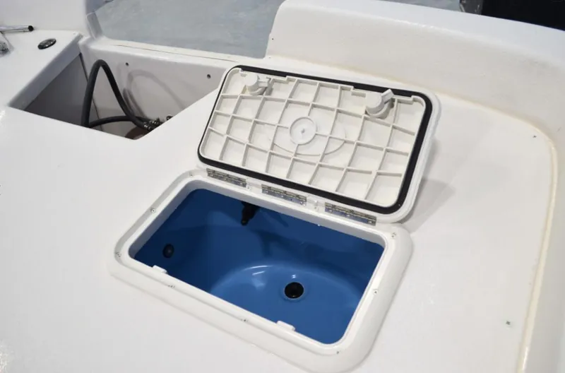 Slide: The Image of 2024 Carolina Skiff E24 DLX TH boat with open storage compartment. - 3