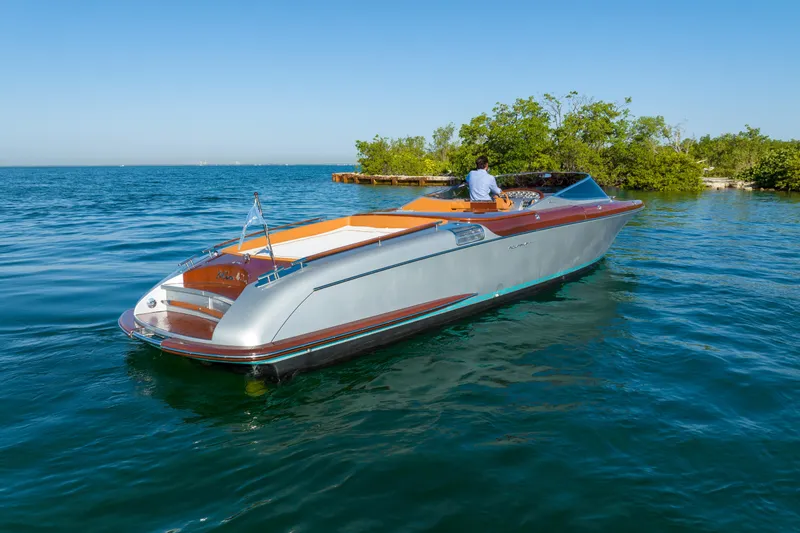 Slide: The Image of 2020 Riva Aquariva Super luxury boat cruising on clear blue water near a small island. - 1