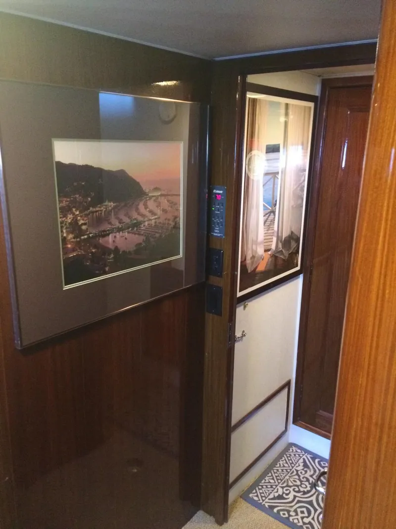 Slide: The Image of Interior hallway of a 1989 Hatteras 70 Cockpit Motor Yacht with framed artwork. - 14