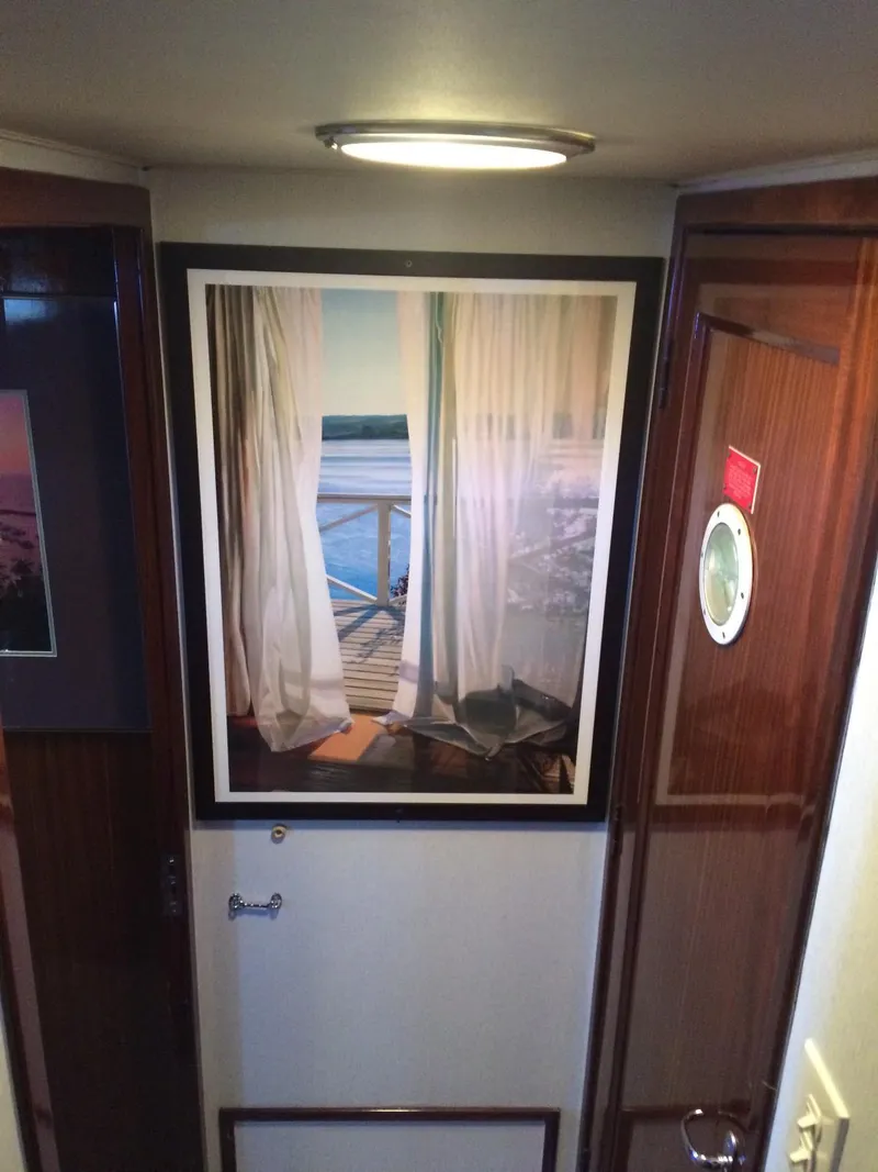 Slide: The Image of Interior of 1989 Hatteras 70 Cockpit Motor Yacht with framed ocean view artwork. - 15
