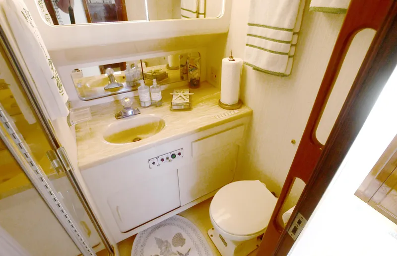Slide: The Image of Bathroom interior of 1989 Hatteras 70 Cockpit Motor Yacht, featuring sink and toilet. - 24