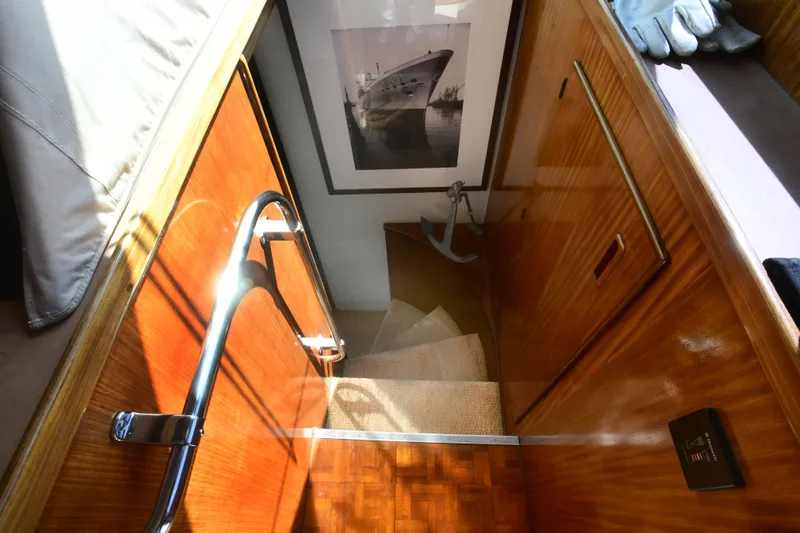 Slide: The Image of Staircase in 1989 Hatteras 70 Cockpit Motor Yacht with wood paneling and nautical decor. - 30