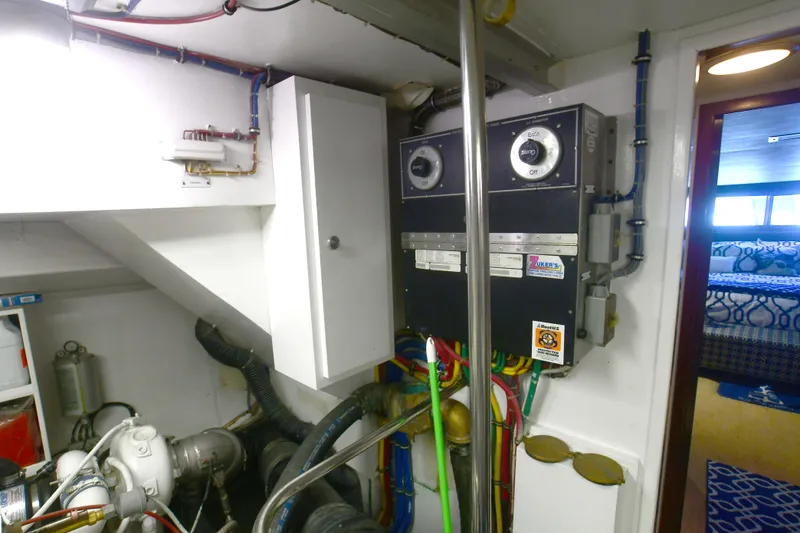 Slide: The Image of Engine room of 1989 Hatteras 70 Cockpit Motor Yacht with control panels and machinery. - 32