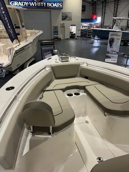 Slide: The Image of 2025 Key West 239 FS boat interior with cushioned seating at a showroom. - 7