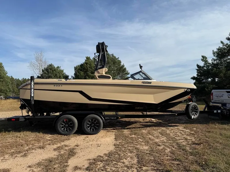 Slide: The Image of 2025 Nautique Super Air GS22 boat on trailer, parked outdoors. - 1