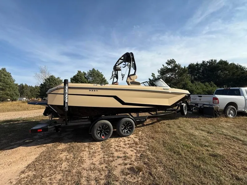 Slide: The Image of 2025 Nautique Super Air GS22 boat on trailer, parked outdoors. - 3