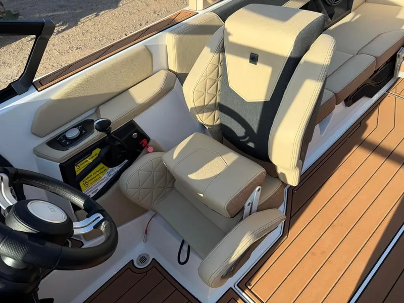 Slide: The Image of 2025 Nautique Super Air GS22 boat interior with beige seating and modern controls. - 30