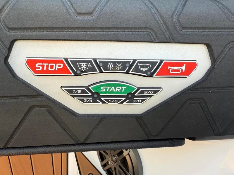 Slide: The Image of Control panel of 2025 Nautique Super Air GS22 boat with start and stop buttons. - 34