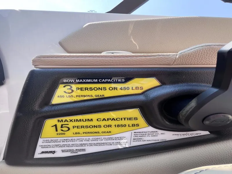 Slide: The Image of Capacity labels on 2025 Nautique Super Air GS22 boat, showing weight and passenger limits. - 36