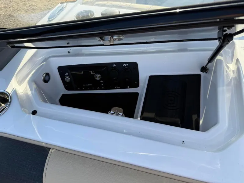 Slide: The Image of 2025 Nautique Super Air GS22 dashboard compartment with control panel and storage. - 47