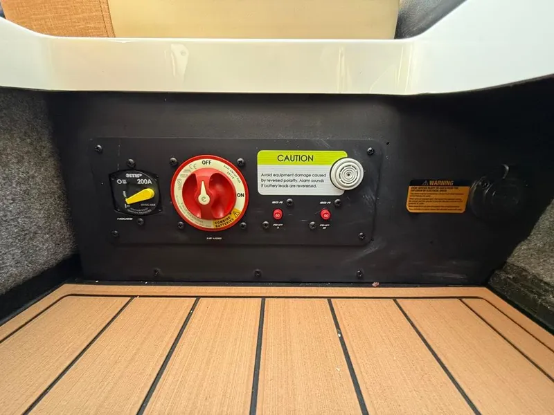 Slide: The Image of 2025 Nautique Super Air GS22 control panel with caution labels and switches. - 50