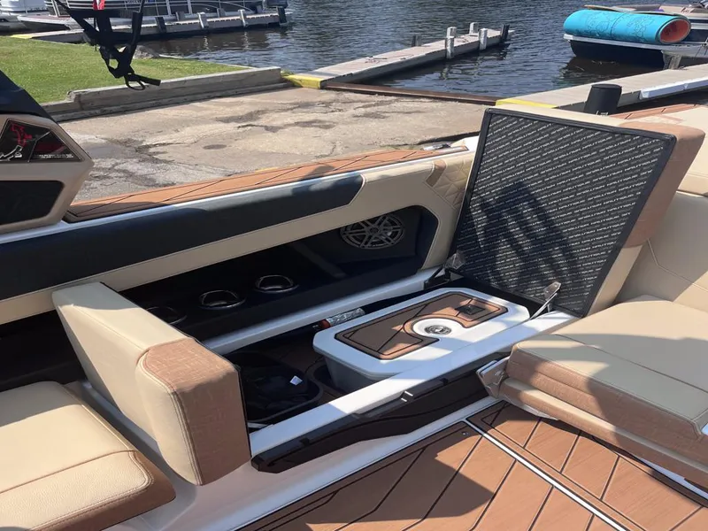 Slide: The Image of 2025 Nautique Super Air GS22 interior with open storage compartment by the dock. - 52
