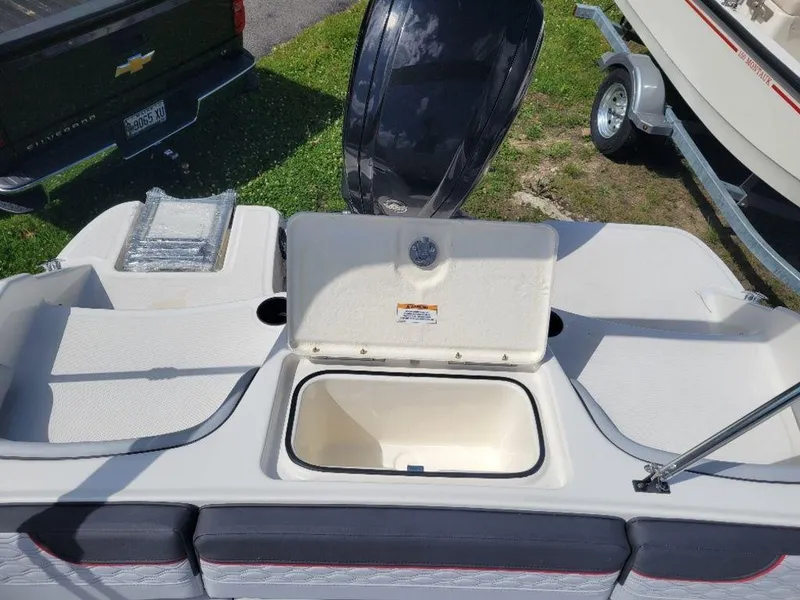 Slide: The Image of Bayliner M17 2024 boat with open storage compartment and outboard motor. - 10