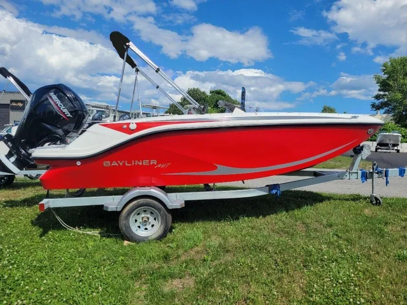 Slide: The Image of 2024 Bayliner M17 boat in red on a trailer, parked on grass. - 2