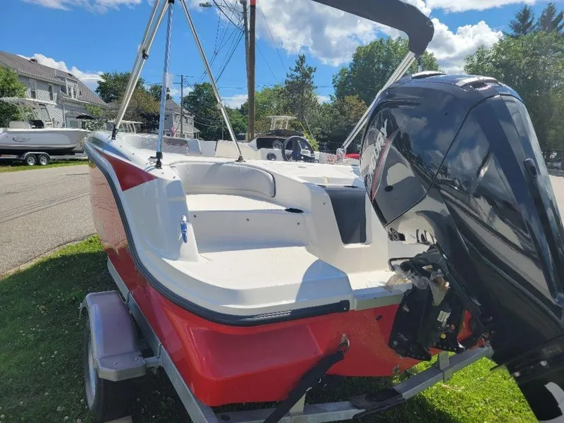 Slide: The Image of 2024 Bayliner M17 boat with red and white exterior, parked on a trailer. - 3