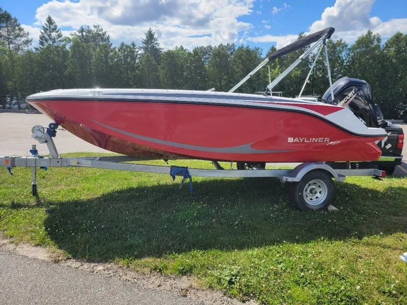 Slide: The Image of 2024 Bayliner M17 boat in red on a trailer, parked on grass. - 5