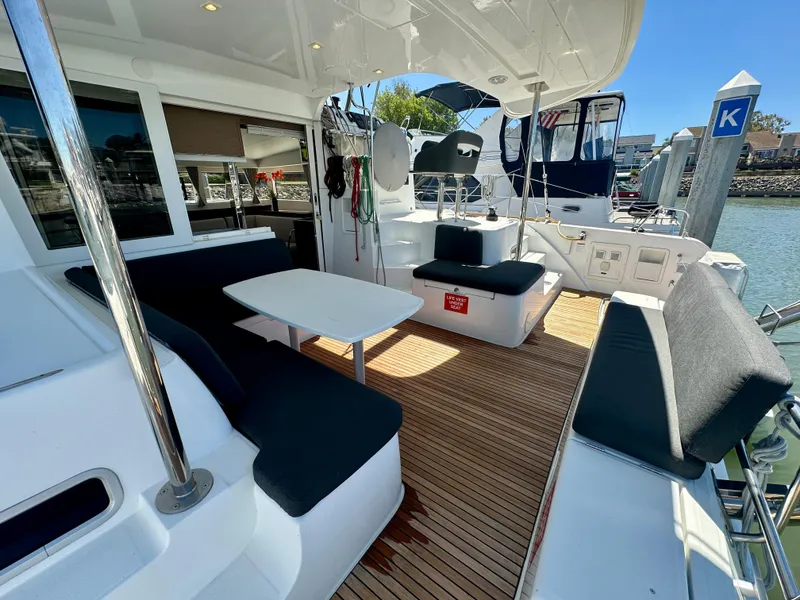 Slide: The Image of Outdoor seating area on a 2020 Lagoon 40 catamaran with a scenic marina view. - 28