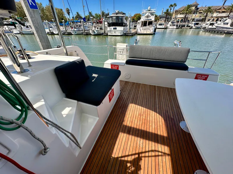 Slide: The Image of Lagoon 40 catamaran 2020 model with spacious deck, seating, and table in marina setting. - 30