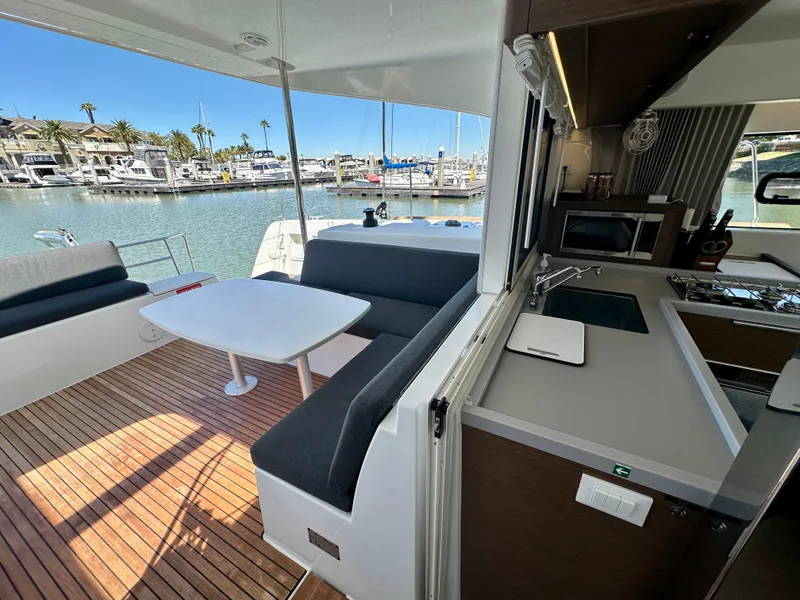 Slide: The Image of 2020 Lagoon 40 catamaran with spacious outdoor seating and dining area at the marina. - 33
