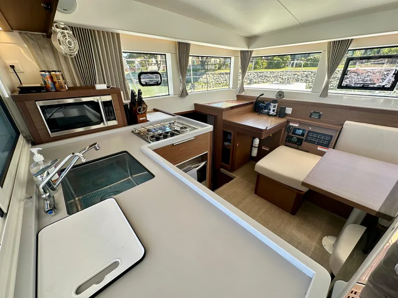Slide: The Image of Modern Lagoon 40 catamaran interior with kitchen and seating area, docked at marina, 2020 model. - 35