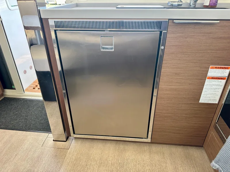 Slide: The Image of Interior of 2020 Lagoon 40 catamaran with modern kitchen and marina view. - 50