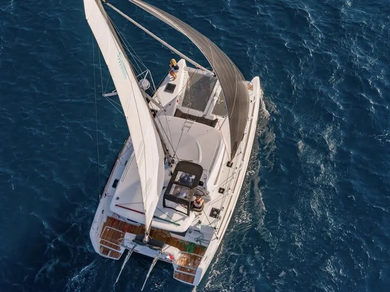 Slide: The Image of 2020 Lagoon 40 catamaran sailing on calm waters with scenic mountain backdrop. - 8