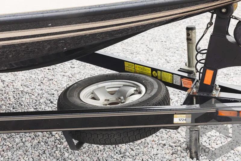 Slide: The Image of 2009 Skeeter ZX 200 boat trailer with spare tire on gravel. - 12